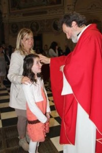 Don Lucio Galbiati impartisce la Cresima ad ragazzina in san Nicolò