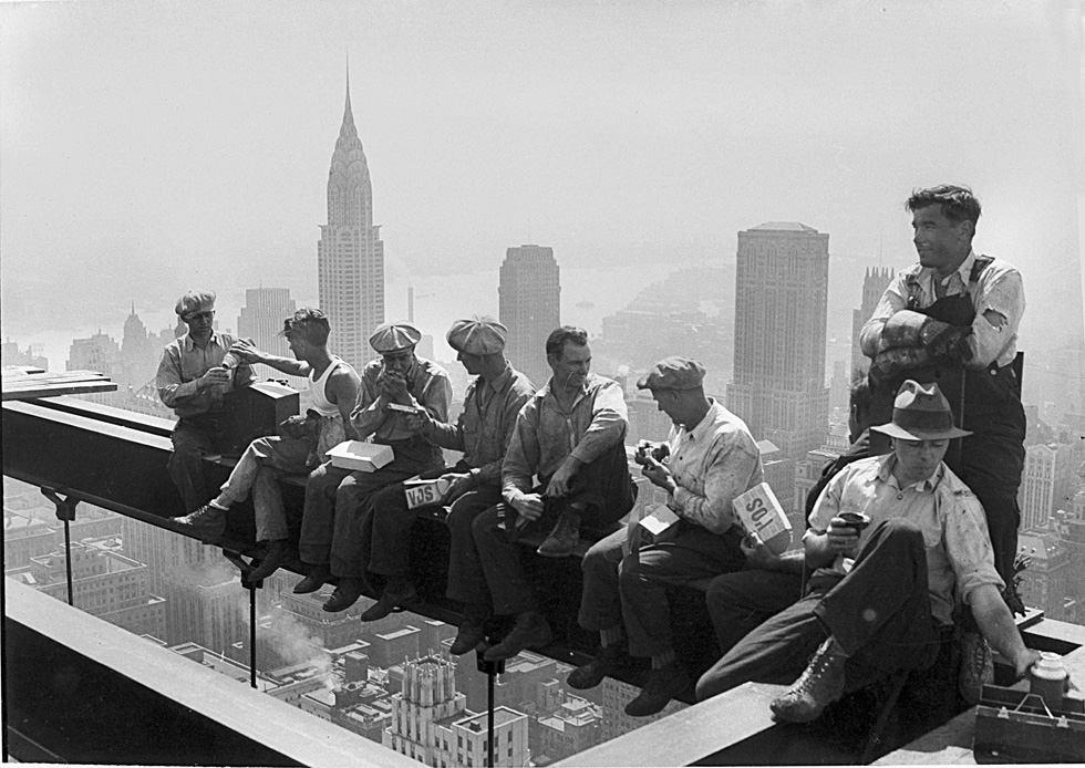 Construction workers take a lunch break on a steel beam atop the RCA Building at Rockefeller Center, New York, Sept. 29, 1932. In the background is the Chrysler Building. (AP Photo)